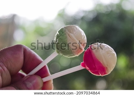 two lollipops with white green and white pink.  lollipops can relax the mind.with a natural background.