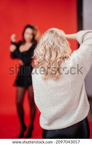 Cute girl photographer taking pictures of a model in a photo studio