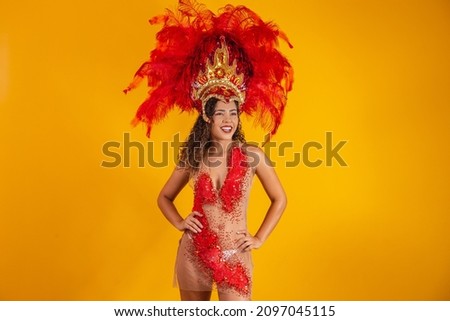 Beautiful young female in special feather costume is dancing at studio.Carnival samba 