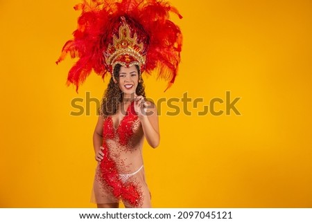 Beautiful young female in special feather costume is dancing at studio.Carnival samba 