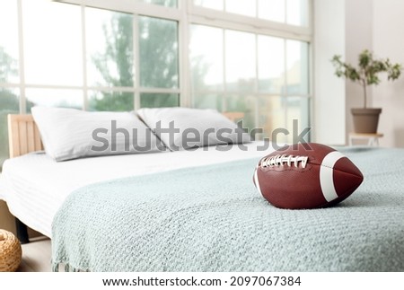 Rugby ball on bed in bedroom