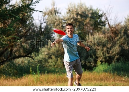 Young man throwing frisbee in park