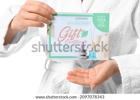 Young woman with gift certificate for massage on white background