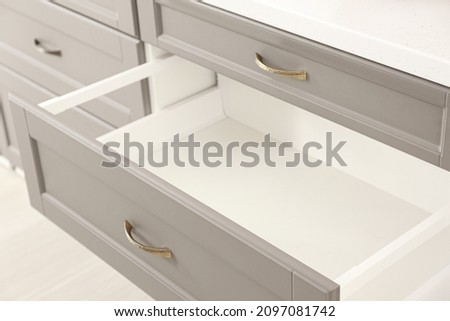 Opened kitchen drawer in room, closeup Royalty-Free Stock Photo #2097081742