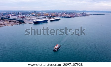 small container ship sailing in sea and shipping port background photograph aerial view from drone cinematic picture style process 