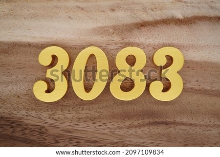 Golden Arabic numerals 3083 on a dark brown to white wood grain background.
