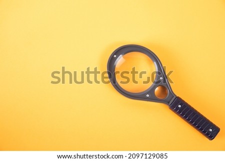 Magnifying glass on an orange background. Search concept.