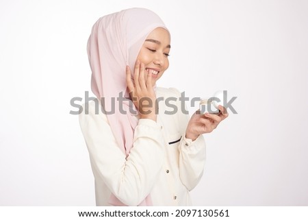 Pretty hijab girl apply new skin care CBD, HEMP cream jar on her face to make face soft fresh nature isolated  Royalty-Free Stock Photo #2097130561