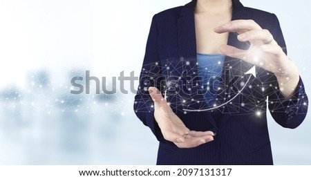 Business growth concept year 2022. Two hand holding virtual holographic growth graph chart, arrow icon with light blurred background. Investment business online concept. Global currency exchange.
