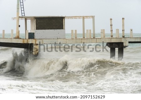 Storm waves on the Black Sea coast, Batumi, Georgia. Huge waves under the pier. Stormy weather.