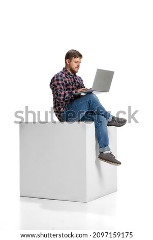 Portrait of young motivated employee, man working on project on laptop isolated over white background. Concept of career, motivation, working experience, projects. Copy space for ad