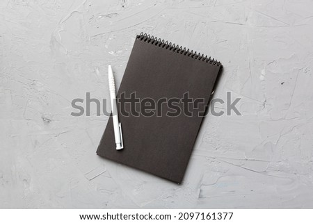 school notebook on a colored background, spiral black notepad on a table Top view.