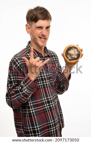 Young handsome tall slim white man with brown hair making horns sign holding kolach in flannel shirt isolated on white background