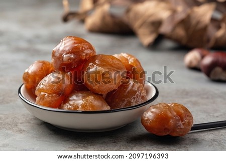 Marron glace,  confection, originating in northern Italy and southern France consisting of a chestnut candied in sugar syrup and glazed. Royalty-Free Stock Photo #2097196393