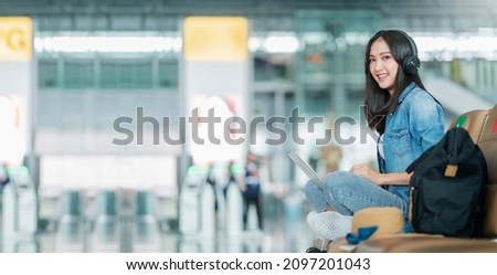 travel vacation concept,pov asian female woman wear headphone hand use laptop hand wave greeting to camera with cheerful and happiness,asian female sit wating at wating area in airport terminal Royalty-Free Stock Photo #2097201043