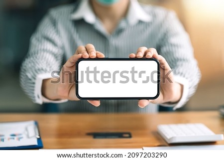 Mock up. Woman holding phone showing blank white screen.