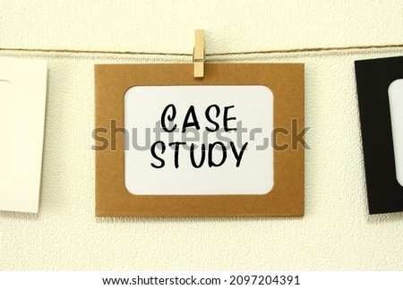 Kraft paper frame hanging on lacing on white wall background with space. In the frame is written the text CASE STUDY.