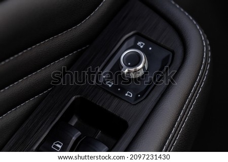 Side mirrors control panel on side door. Car driver adjust side mirror controller. Side mirror control button for adjusting the mirrors. Royalty-Free Stock Photo #2097231430
