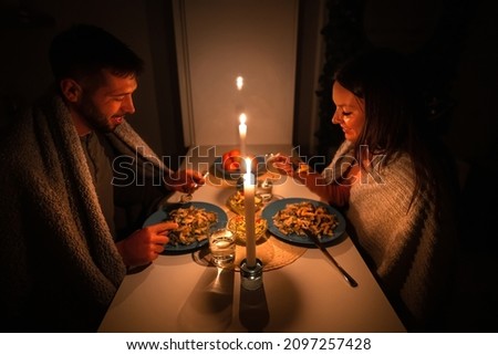 Couple having dinner at home during power outage. Blackout, no electricity Royalty-Free Stock Photo #2097257428