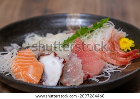 Take a picture of a platter of Japanese sashimi on a plate