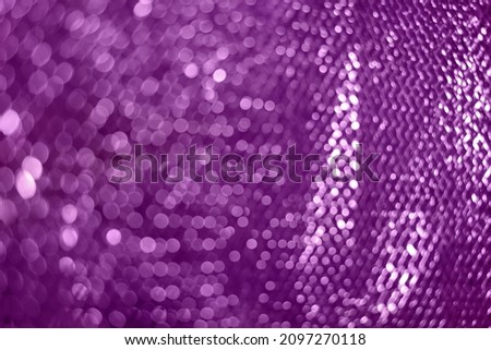 Violet glitter spots bokeh color. Defocused sparkling glittery texture. Blurred background. Festive concept.