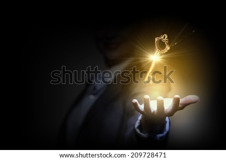 Close up image of business person holding shining key Royalty-Free Stock Photo #209728471