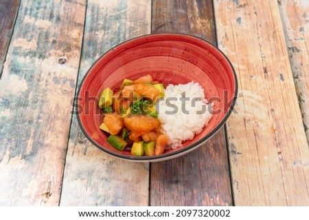 salmon and avocado tartare with cooked white rice on wooden table