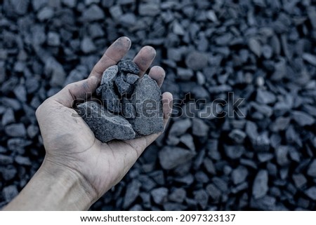 Coal mining : coal miner in the man hands of coal background. Picture idea about coal mining or energy source. Industrial coals. Volcanic rock.