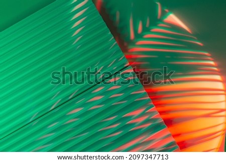 Palm tree leaves on abstract background with podiums in neon light. Trendy geometric shapes for products. Red and green gradient light. Minimalism, 90s, 80s concept. Royalty-Free Stock Photo #2097347713
