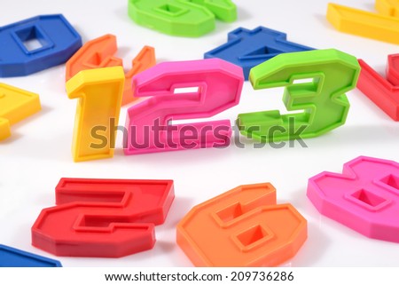 Colorful plastic numbers 123 on white background