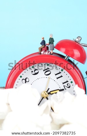 The old couple doll models in the miniature world are on the alarm clock