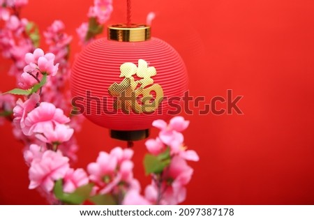 Chinese new year decoration Red lantern and peach blossom，the word inside picture means blessing.