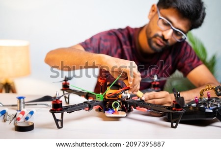 Selective focus on Quadcopter, Engineer student connecting battery to drone at home laboratory - concept of UAV Experiment by testing and assembling Royalty-Free Stock Photo #2097395887