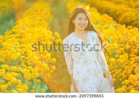 Vintage Photography style of Pretty Asian woman portrait with yellow marigold garden in sunset time background, selected focus.