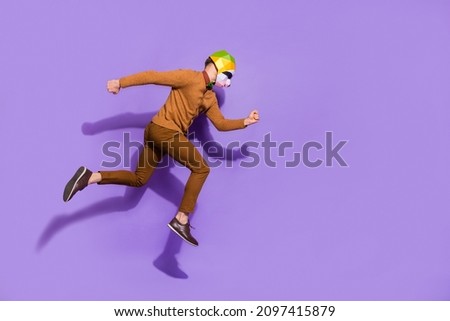 Full size profile portrait of active energetic red panda mask guy running isolated on violet color background