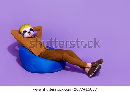 Full body profile side photo of young guy enjoy free-time sit hands behind head isolated over purple color background