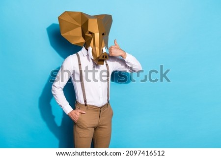Photo of charming funky guy dressed wild animal mask showing thumb up empty space isolated blue color background