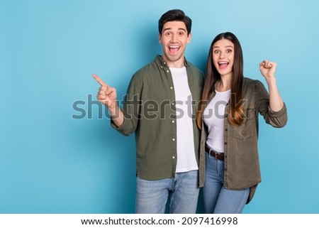 Photo of crazy lady guy celebrate luck lottery win ads indicate point hand empty space fists up isolated on blue color background