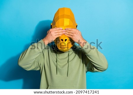 Photo of scared upset guy dressed wild animal mask arms cover eyes isolated blue color background
