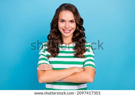 Photo of manager brunette curly young lady crossed arms wear green t-shirt isolated on blue color background