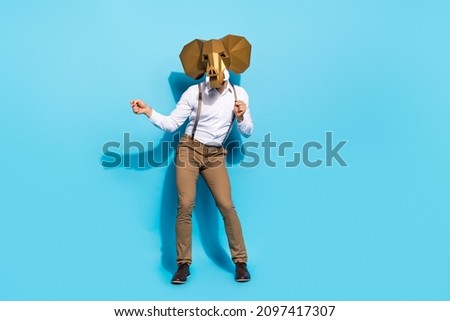 Full size photo of young guy celebrate halloween incognito dancing hang-out isolated over blue color background