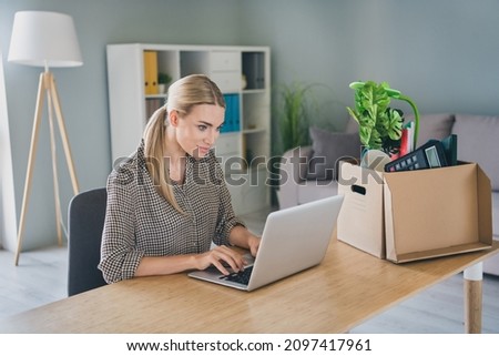 Photo of focused ambitious mature manager lady fired age discrimination use notebook find recruiter work sit desk modern workspace