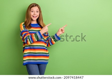 Portrait of attractive girly cheerful amazed girl demonstrating new novelty copy space isolated over bright green color background