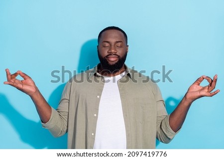 Photo of young african man meditate dreamy practicing relax calm casual isolated over blue color background