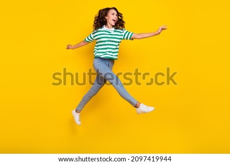Full body photo of cool brunette millennial lady run wear t-shirt jeans sneakers isolated on yellow background