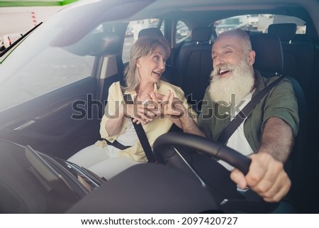 Portrait of attractive elderly retired cheerful couple riding car having fun telling funny stories spending holiday day rest Royalty-Free Stock Photo #2097420727