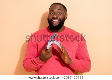 Photo of nice millennial brunette guy hold much money wear pink pullover isolated on beige color background