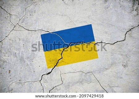An old image of the flag of Ukraine on a wall with a crack. A crisis. Royalty-Free Stock Photo #2097429418