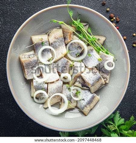 herring slice pieces of fish with onion seafood healthy meal food snack on the table copy space food background rustic top view keto or paleo diet pescetarian  Royalty-Free Stock Photo #2097448468