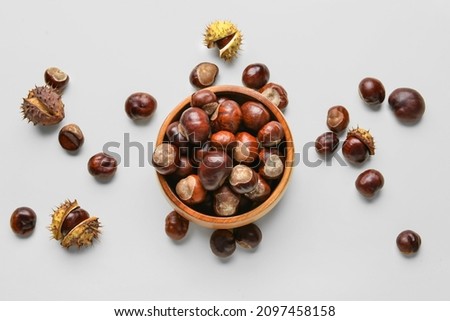 Bowl full of brown chestnuts on white background Royalty-Free Stock Photo #2097458158